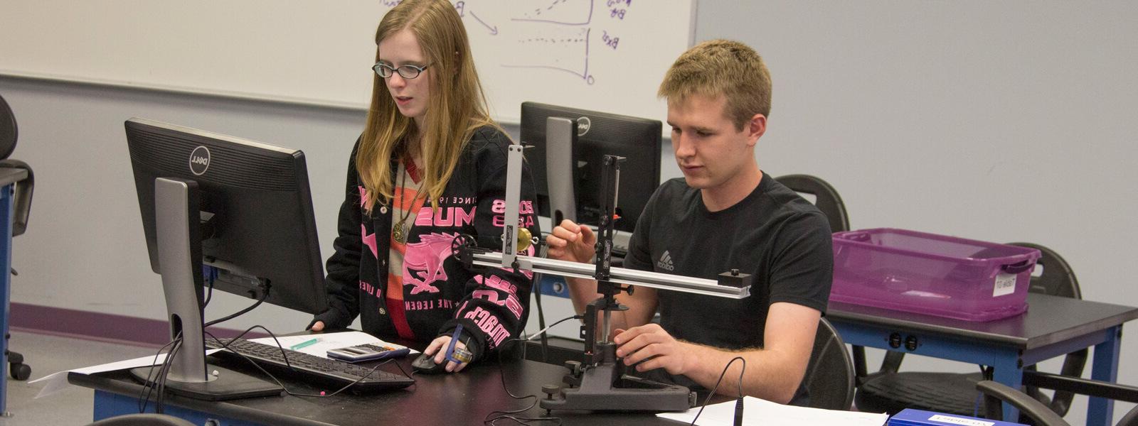 two students work on physics project